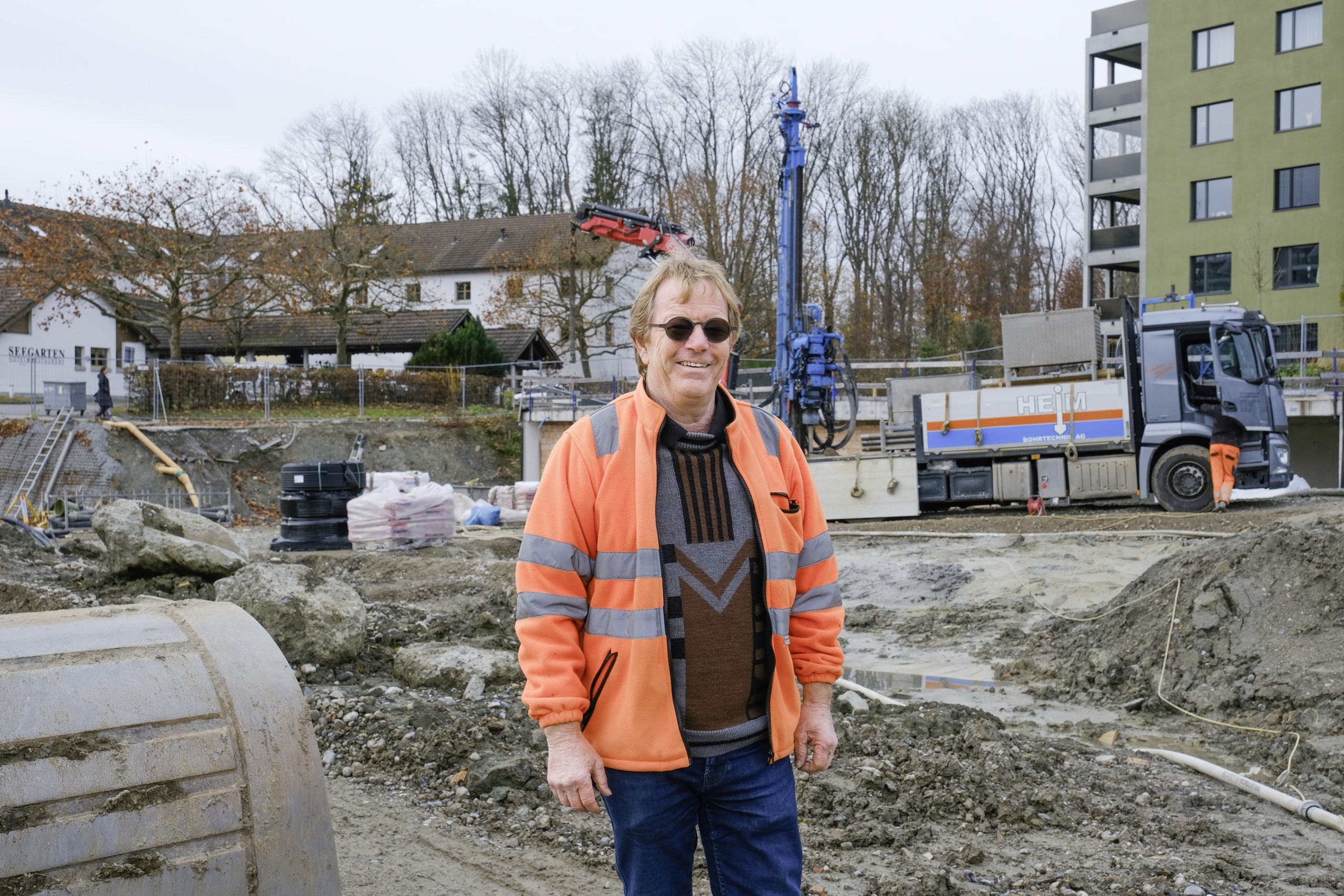 Auf dem «Seemoosholz» geht es unterschiedlich schnell zu und her: Während die Wohnblöcke an der Seestrasse bereits im nächsten Jahr alle einzugsbereit sein sollen (Bild rechts), konnten die Bauarbeiten für die zweite Etappe an der Seemoosholzstrasse gerade erst aufgenommen werden (Bild links). Der Erdsondenbohrer hinter Rolf Bressan stand als erste Maschine auf dem Platz.