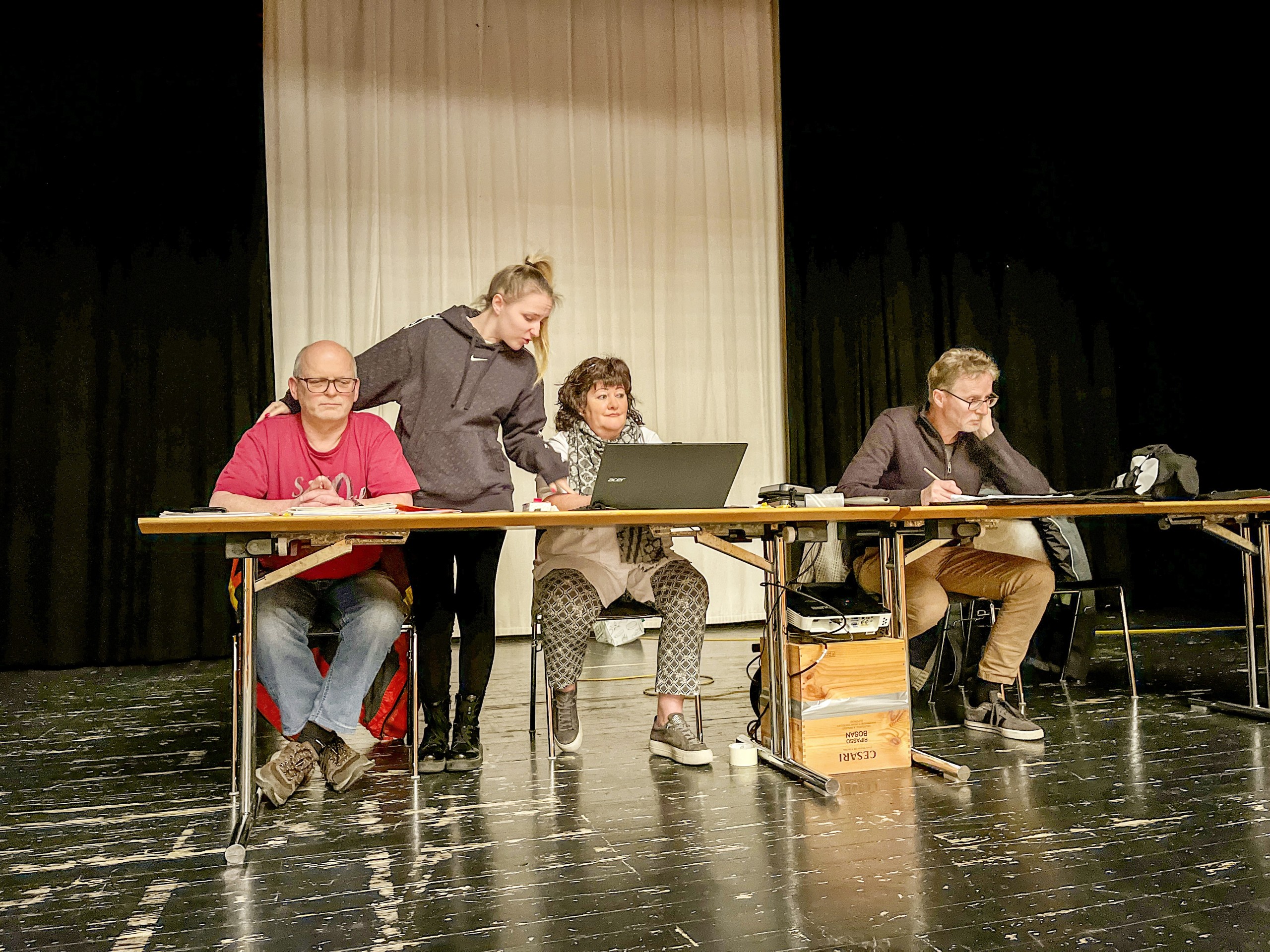 Schon wieder wird die Versammlung gestört: Nicole, die KV-Lernende der Gemeindeverwaltung (2.v.l.), hilft einmal mehr der Gemeindeschreiberin Marina Giannini (3.v.l.), weil diese mit dem Programm auf dem Laptop überfordert ist.